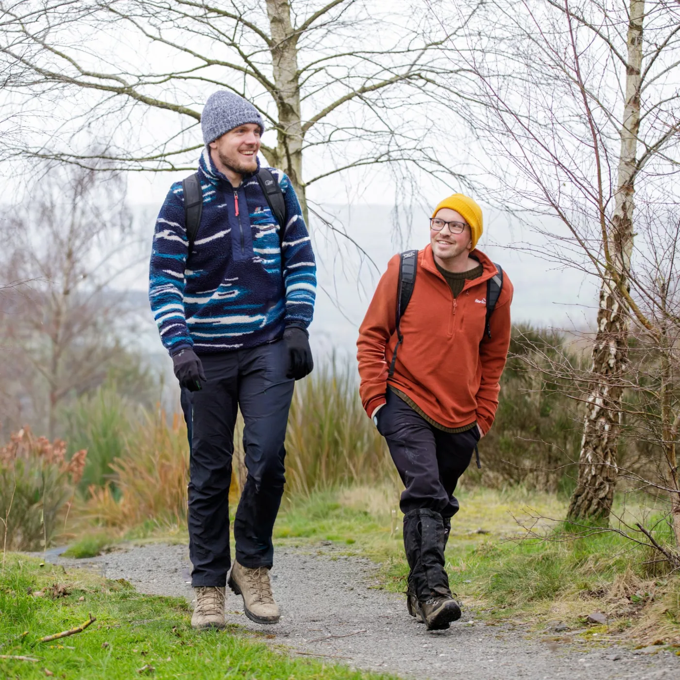 Andy and a friend walking a gravel path through birch woods